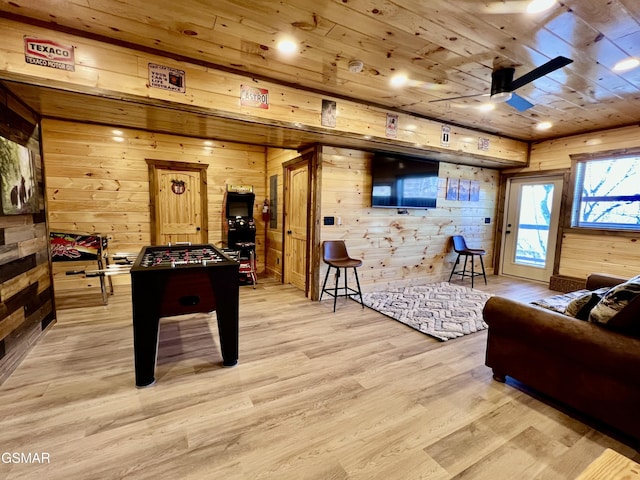 playroom featuring light hardwood / wood-style floors, ceiling fan, wood walls, and wooden ceiling