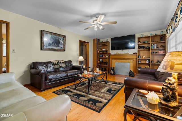 living room featuring a fireplace, hardwood / wood-style flooring, and ceiling fan