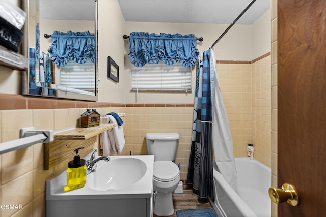 full bathroom with shower / bath combination with curtain, toilet, tile walls, and vanity