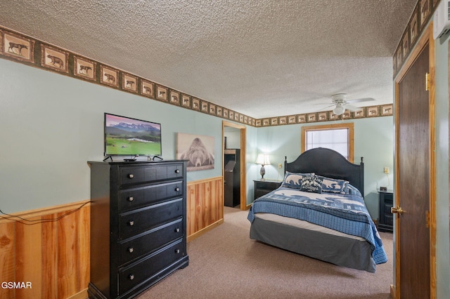 bedroom with carpet floors, a textured ceiling, and wood walls