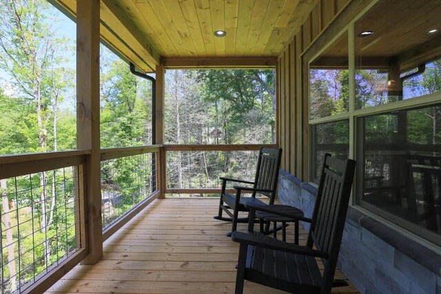 living room with a wall mounted AC, wooden ceiling, ceiling fan, and light hardwood / wood-style flooring