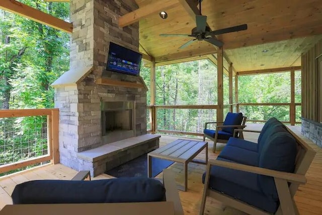 exterior space featuring an outdoor living space with a fireplace and ceiling fan