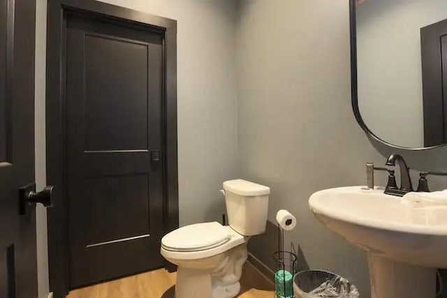 bathroom featuring wood-type flooring and toilet