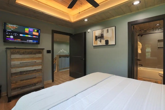 bedroom with hardwood / wood-style floors, wooden ceiling, a raised ceiling, and ensuite bathroom