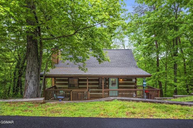 view of front of home with a shingled roof and a chimney