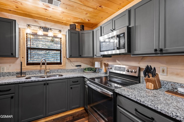 519 Mcmahan Rd, Pigeon Forge, TN 37863 - kitchen with stainless steel appliances, light stone countertops, gray cabinets, and wooden ceiling