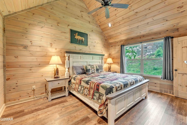 bedroom with lofted ceiling, wood ceiling, light wood-style floors, wood walls, and ceiling fan