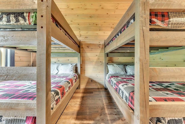 bedroom featuring wood finished floors and wooden walls