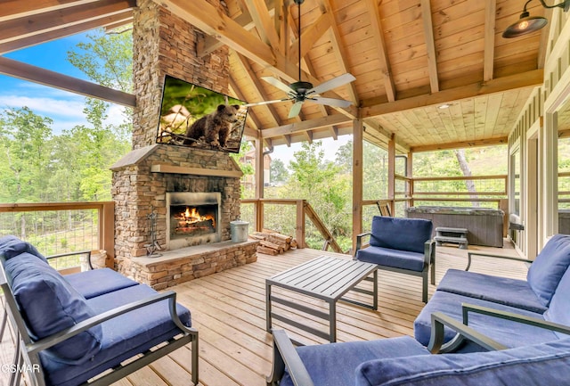 sunroom / solarium featuring an outdoor living space with a fireplace, a jacuzzi, ceiling fan, and plenty of natural light