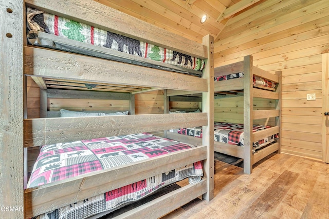 bedroom featuring wood walls and wood finished floors