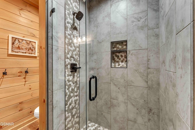 full bath with a shower stall, toilet, and wood walls