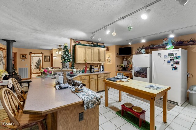 1878 Omaha Rd, Del Rio, TN 37727 - kitchen with freestanding refrigerator, a sink, a peninsula, light countertops, and a wood stove