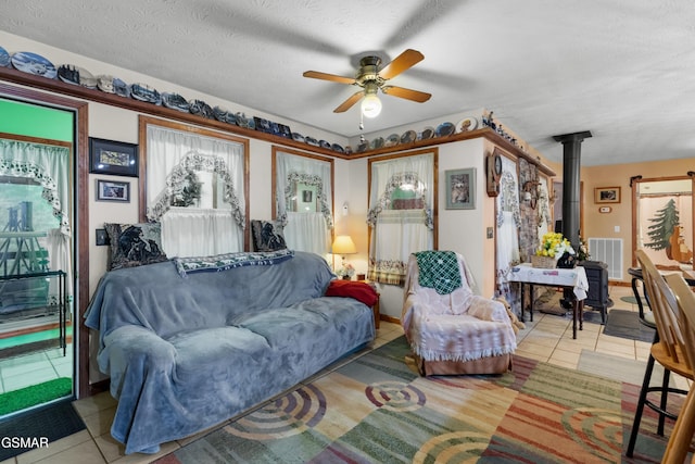 1878 Omaha Rd, Del Rio, TN 37727 - living room with a wood stove, light tile patterned flooring, ceiling fan, and a textured ceiling