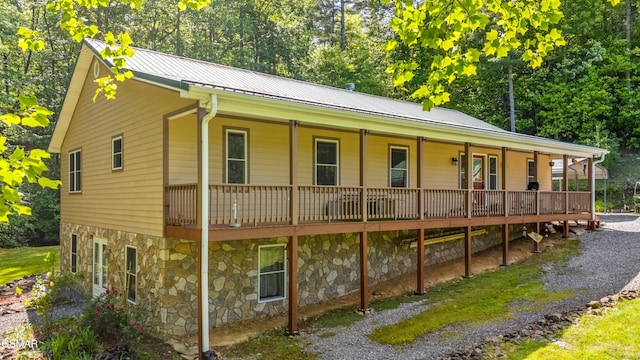 1878 Omaha Rd, Del Rio, TN 37727 - view of front facade with stone siding, covered porch, metal roof, and view of scattered trees