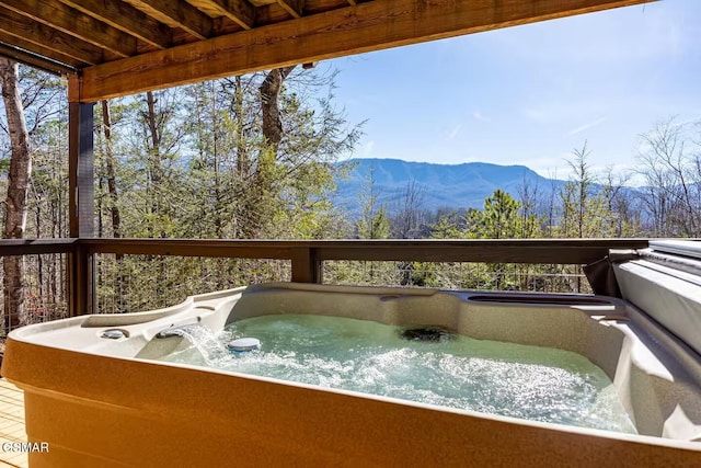 wooden terrace featuring a hot tub and a mountain view