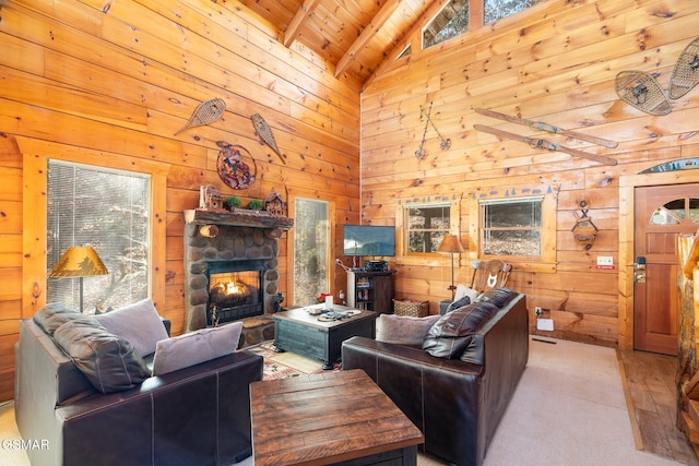 living room featuring high vaulted ceiling, wooden ceiling, beamed ceiling, a stone fireplace, and wood walls