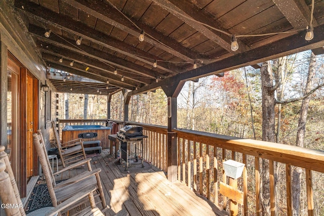 wooden terrace with a hot tub and a grill