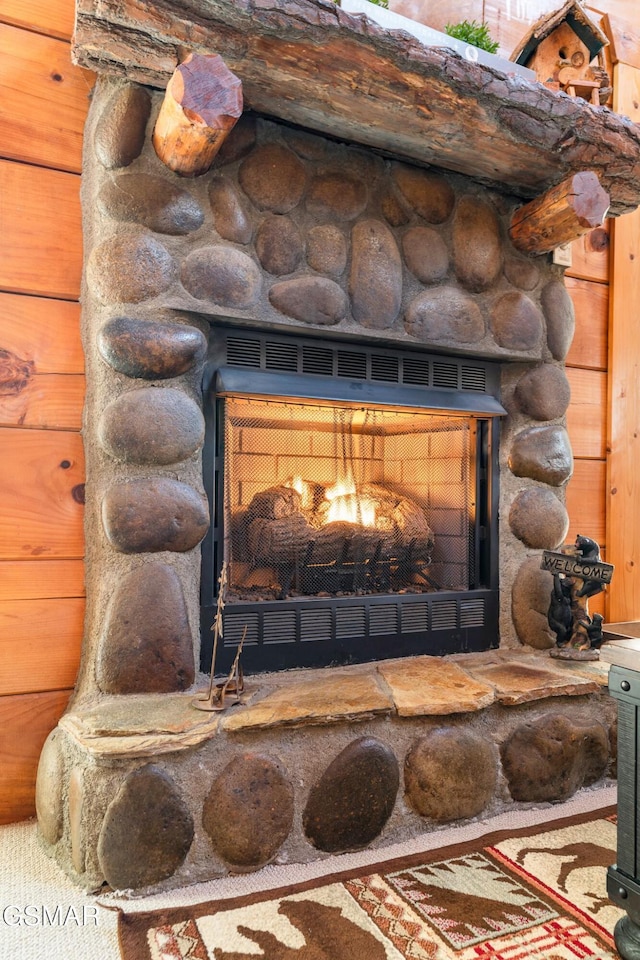 interior details featuring a fireplace and wood walls