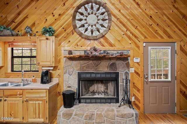4164 Lumber Jack Way, Sevierville, TN 37876 - kitchen featuring vaulted ceiling, a sink, wood walls, light brown cabinets, and a fireplace