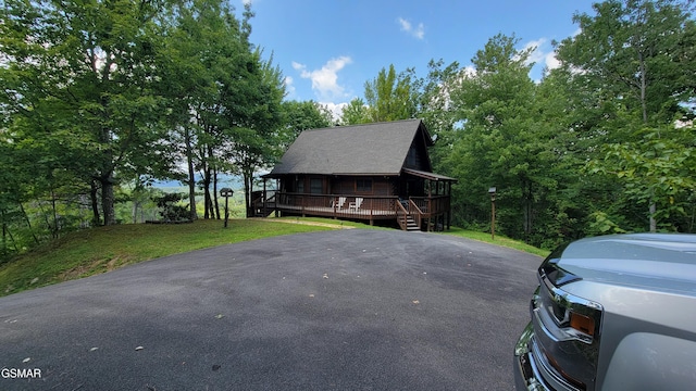 view of front of property featuring a deck and a front yard