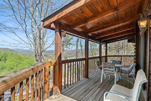 deck featuring outdoor dining area and a mountain view