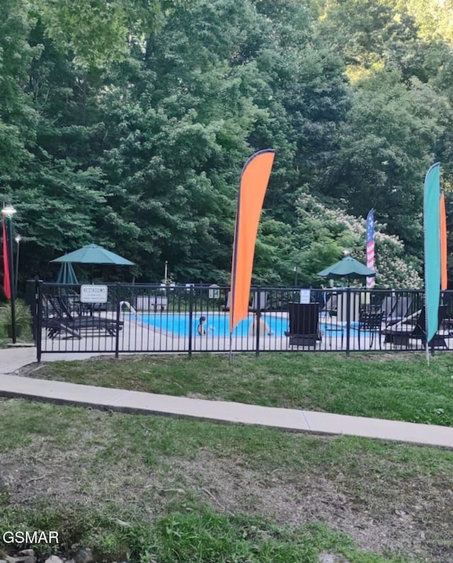 view of playground with a community pool and fence