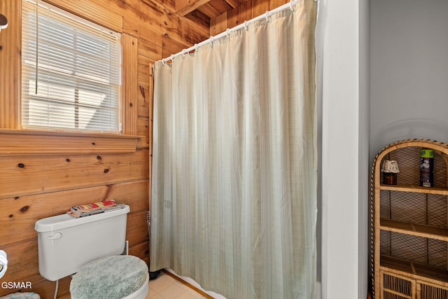 bathroom with wood walls, toilet, and a shower with curtain