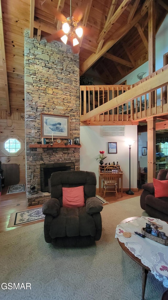 living room featuring high vaulted ceiling, a stone fireplace, wood ceiling, a ceiling fan, and beamed ceiling