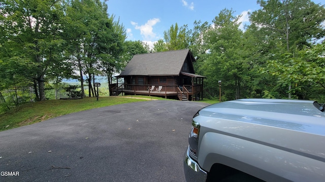 view of front facade featuring a front yard and a wooden deck