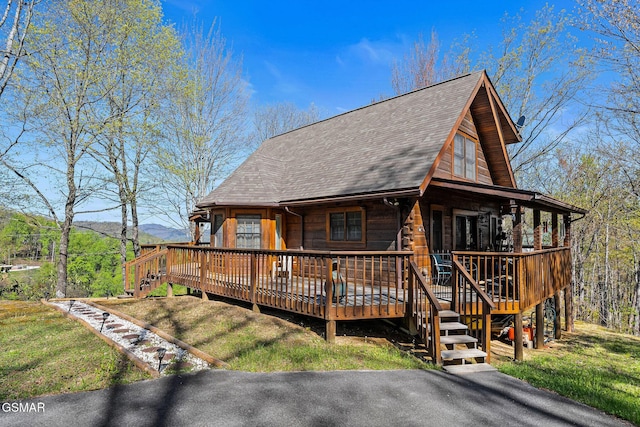 back of property with a shingled roof and a mountain view