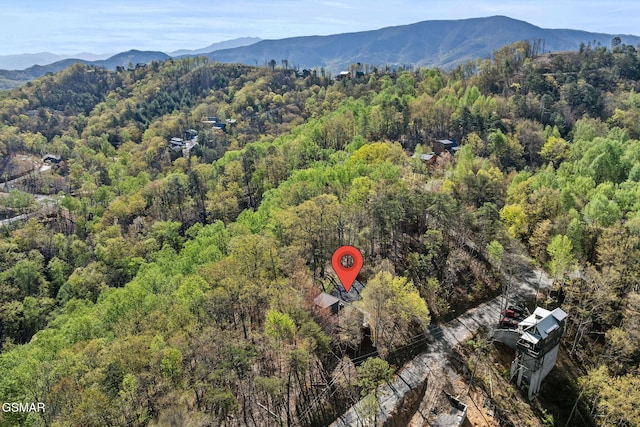 drone / aerial view featuring a view of trees and a mountain view