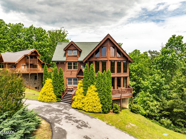 view of front of house with a wooden deck and a front lawn