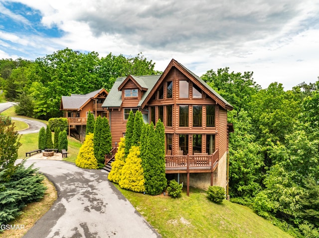 view of front of property featuring a deck and a front lawn