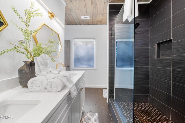 bathroom featuring tile patterned flooring, vanity, a tile shower, and wooden ceiling