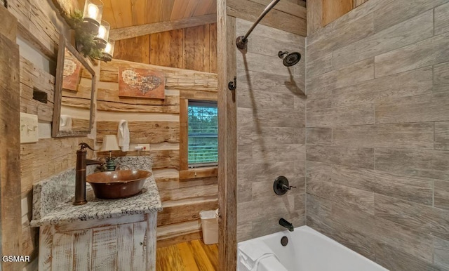 bathroom with vanity, wood-type flooring, tiled shower / bath combo, and wood ceiling