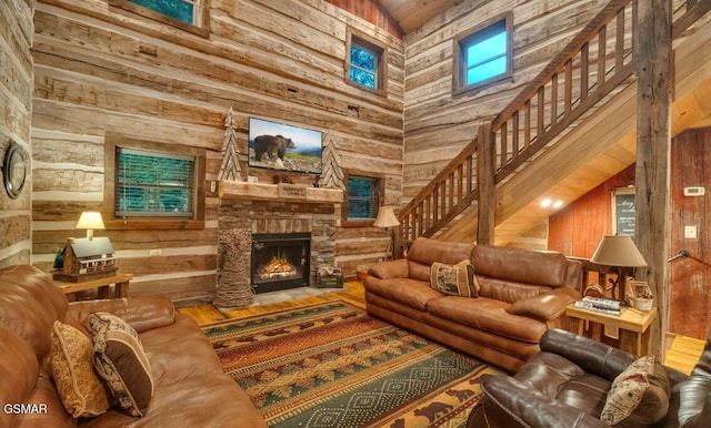 living room with wooden ceiling, high vaulted ceiling, wooden walls, a fireplace, and wood-type flooring