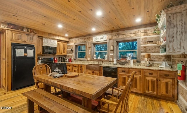 kitchen featuring sink, wooden ceiling, light stone counters, light hardwood / wood-style floors, and black appliances