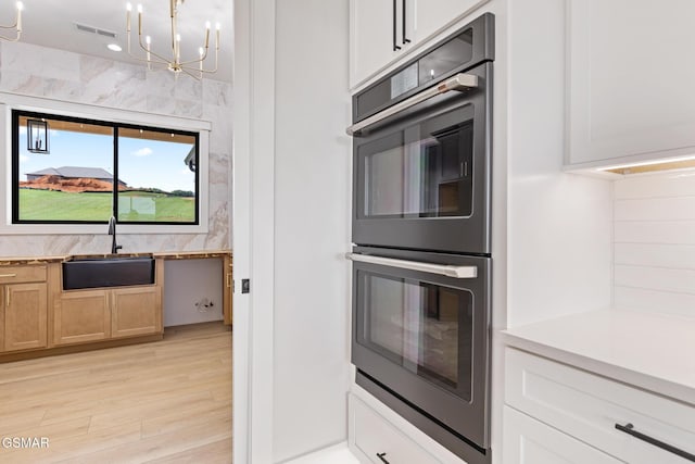 206 Eagle View Dr, Dandridge, TN 37725 - kitchen featuring stainless steel double oven, light wood-style floors, a chandelier, and light countertops