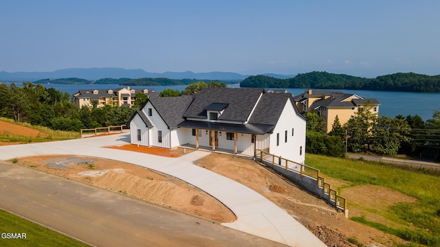 206 Eagle View Dr, Dandridge, TN 37725 - modern farmhouse with a porch, curved driveway, a shingled roof, and a water and mountain view