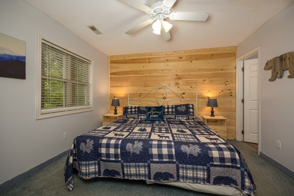 bedroom featuring carpet, ceiling fan, and wood walls