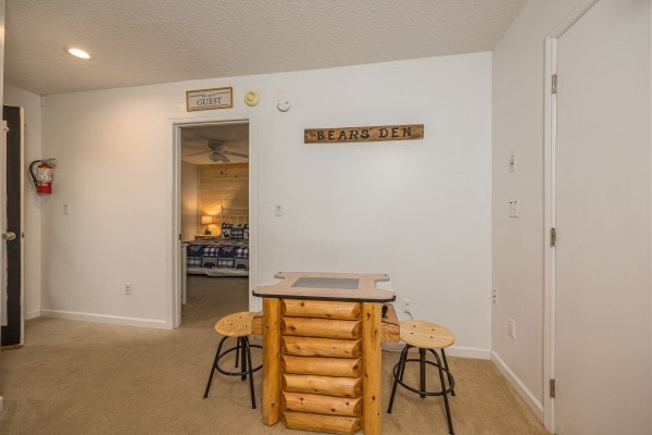 dining area with light colored carpet and a textured ceiling