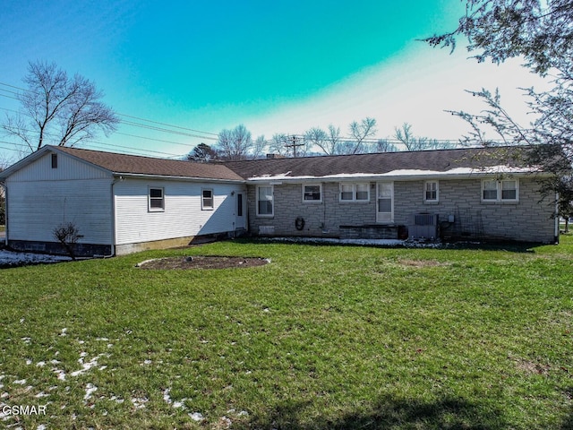 back of property with central air condition unit and a yard