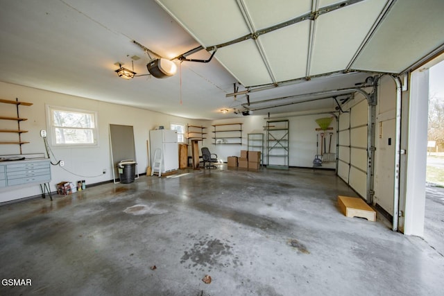 garage with a garage door opener and white fridge