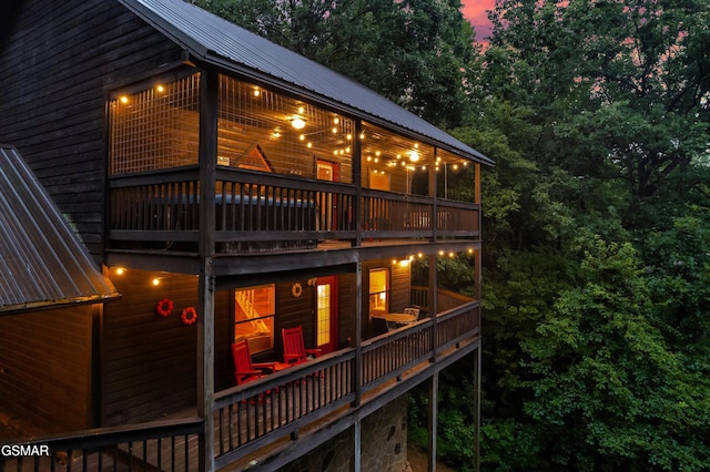 back house at dusk with a balcony