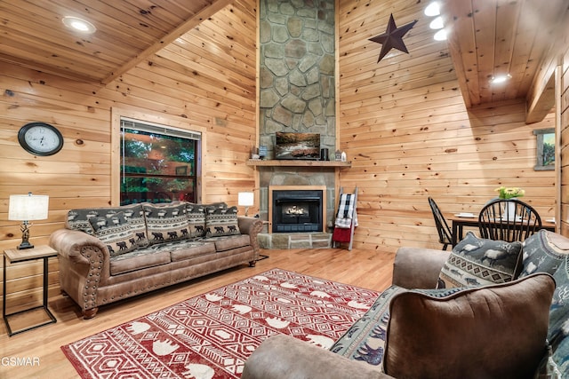 living room featuring hardwood / wood-style flooring, wooden walls, wood ceiling, and a fireplace