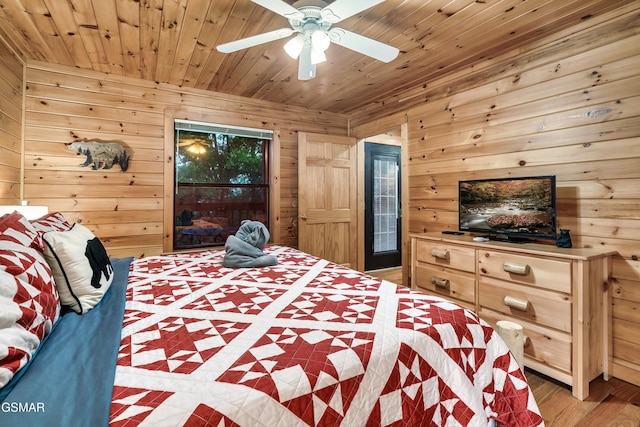 bedroom with hardwood / wood-style floors, wooden walls, access to outside, ceiling fan, and wood ceiling