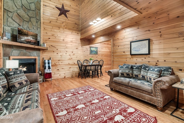 living room with wooden walls, hardwood / wood-style floors, and a fireplace