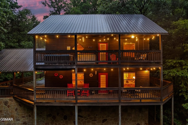 back house at dusk with a balcony