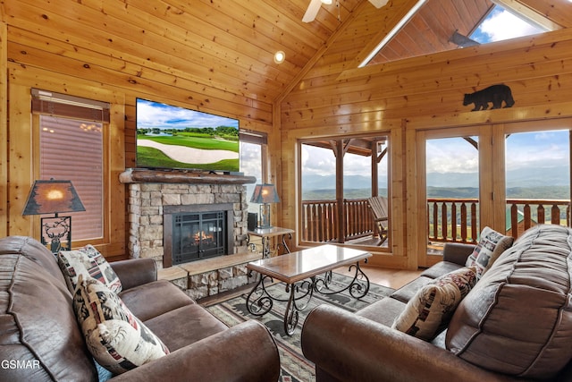 2326 Top Of The World Dr, Sevierville, TN 37876 - living area featuring wood walls, a fireplace, a ceiling fan, wooden ceiling, and high vaulted ceiling