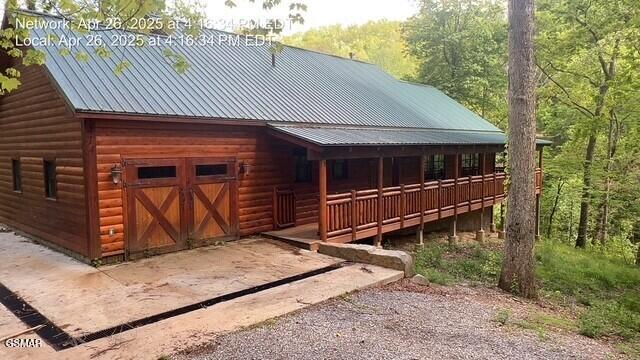 414 Swaying Pines Dr, Sevierville, TN 37876 - view of front of home featuring faux log siding, a metal roof, and a wooded view